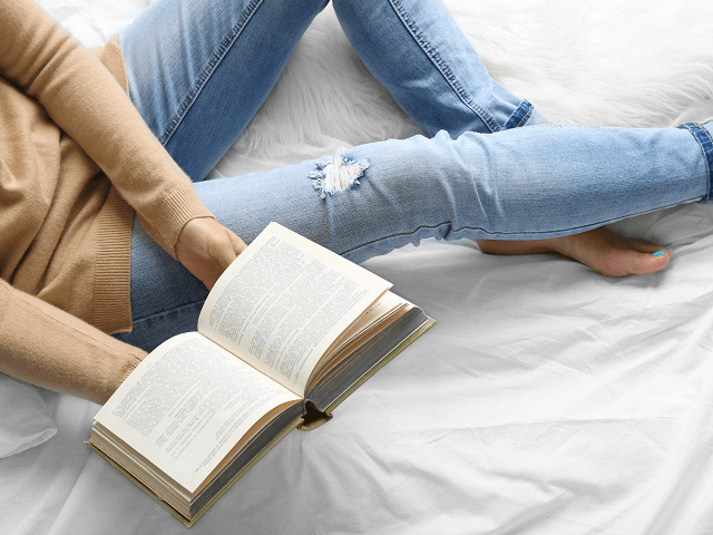 Žena v modrých nohaviciach číta knihu